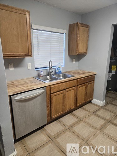 A kitchen with wooden cabinets and a sink.