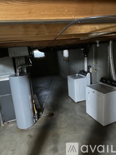 A dirty basement with a washer and dryer.