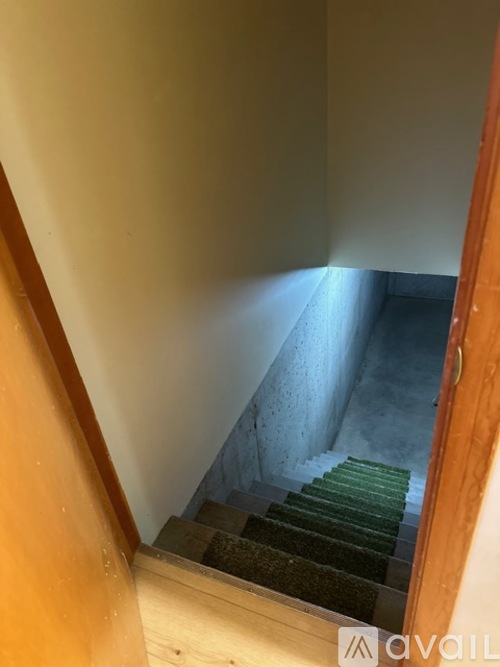 A staircase with a green carpeted runner.