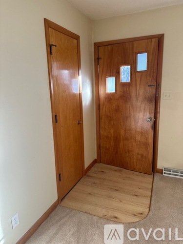 A room with two wooden doors and a carpeted floor.