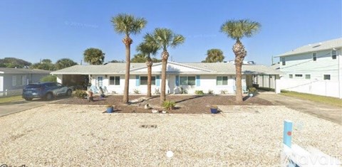 A sunny day at a residential area with a house and palm trees.