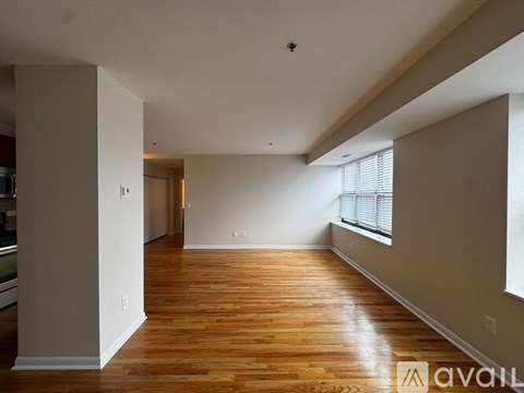 A spacious room with wooden floors and white walls.