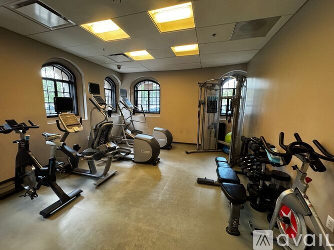 A gym with a variety of exercise equipment including treadmills, stationary bikes, and weight machines.