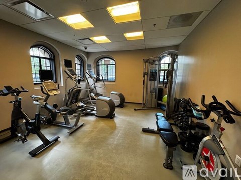 A gym with a variety of exercise equipment including treadmills, stationary bikes, and weight machines.
