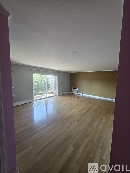 A room with wooden flooring and a window.