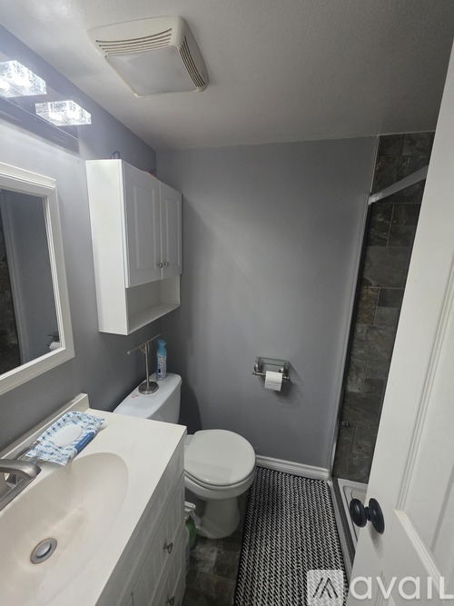 A bathroom with a toilet, sink, and a window.