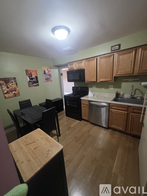 A kitchen with wooden floors and a black stove top oven.