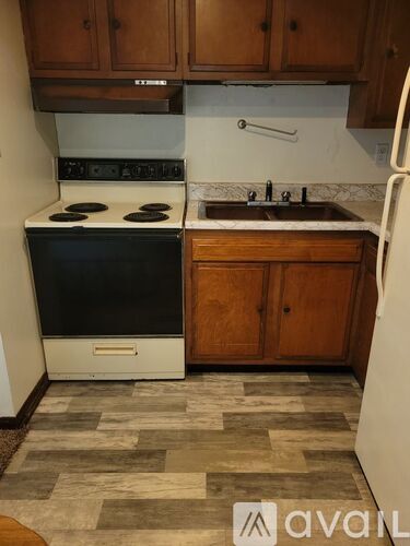 A kitchen with a black stove top oven and a white refrigerator.