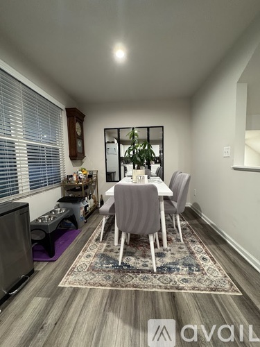 A dining room with a table set for two and a television.