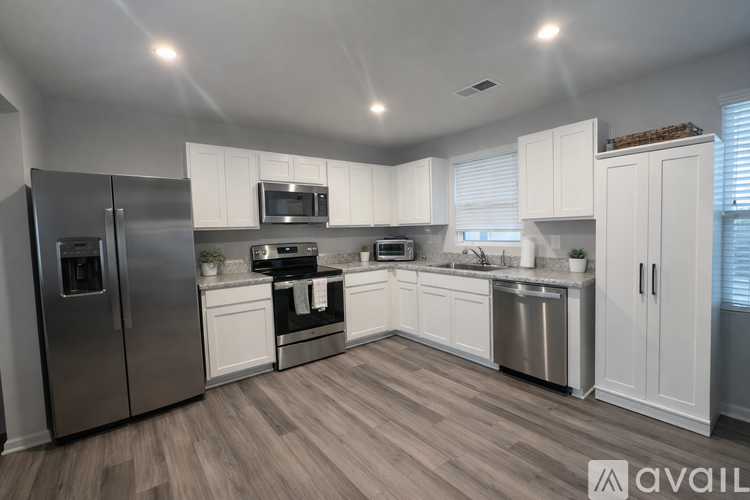 A modern kitchen with white cabinets and stainless steel appliances.