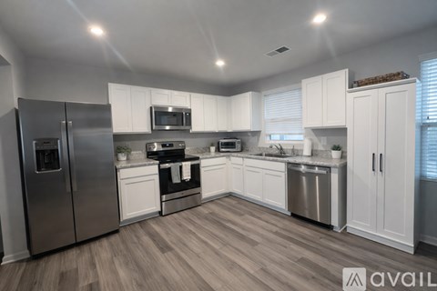 A modern kitchen with white cabinets and stainless steel appliances.