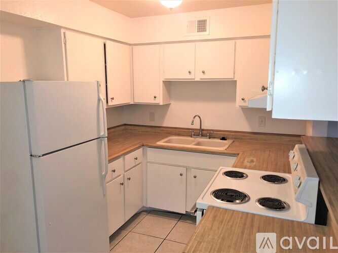 A kitchen with white appliances and cabinets.