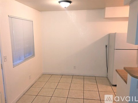 A small, empty room with a window and a door.