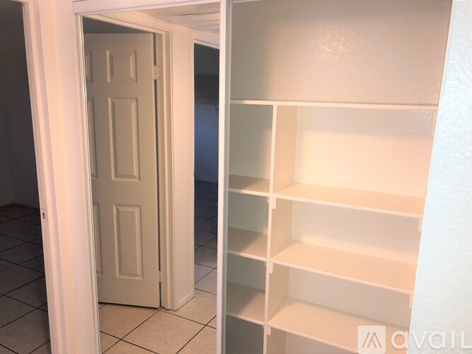 A white door is open to a white pantry.