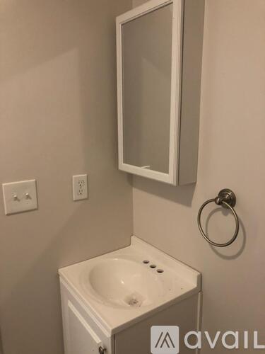A white sink in a bathroom with a mirror above it.