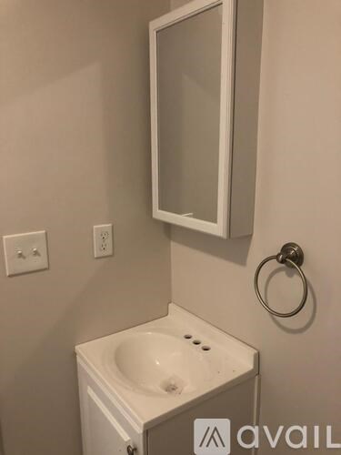 A white sink in a bathroom with a mirror above it.