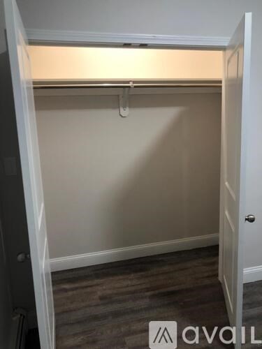 A small, empty room with a door on the left and a door on the right.