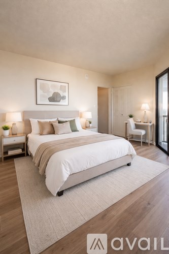 A bedroom with a large bed and a painting on the wall.