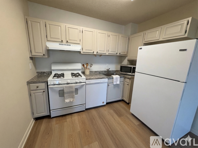 A kitchen with a white refrigerator, white stove, and white oven.