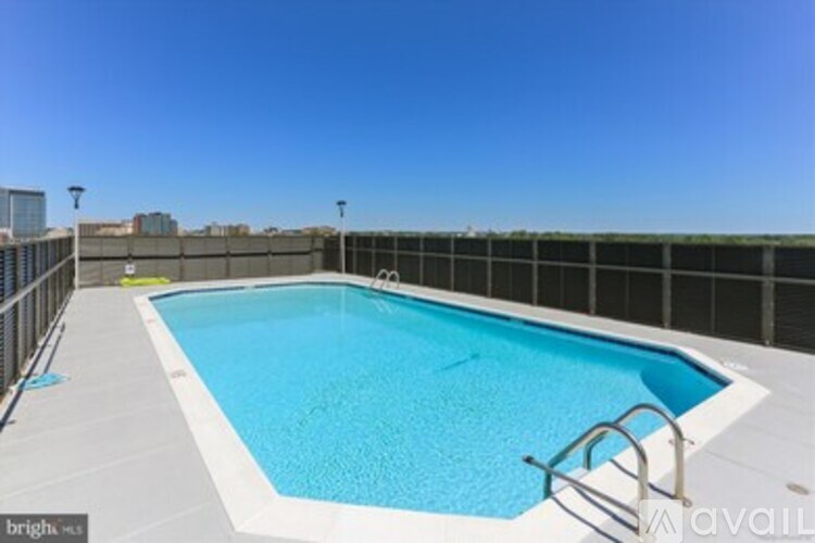 A rectangular blue swimming pool with a metal fence around it.