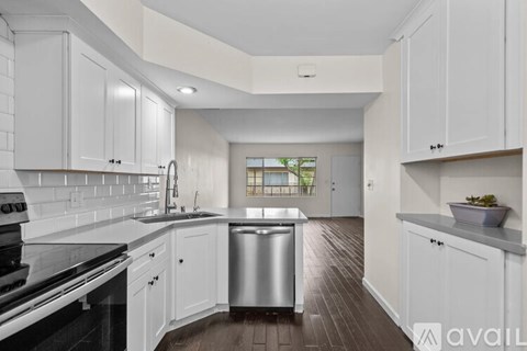 A modern kitchen with white cabinets and a stainless steel dishwasher.