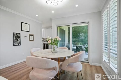 A dining room with a white table and chairs.