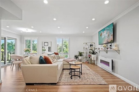 A living room with a beige couch and a fireplace.