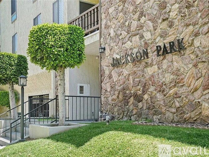 Jackson Park is a residential building with a stone wall and a green lawn.