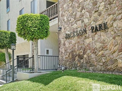 Jackson Park is a residential building with a stone wall and a green lawn.