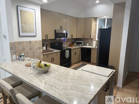 A kitchen with a table and chairs and a bowl of bananas on the table.
