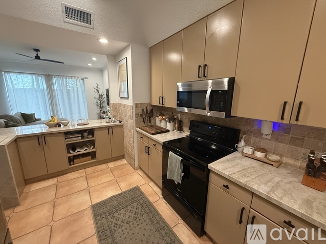 A kitchen with a black stove top oven and a microwave above it.