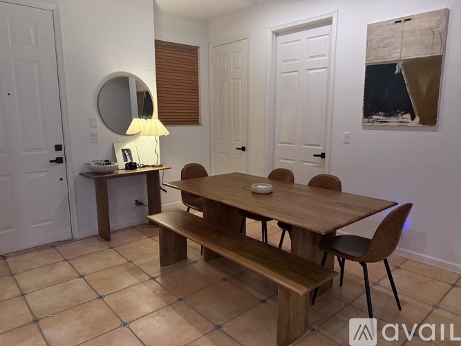 A dining room with a wooden table and chairs.