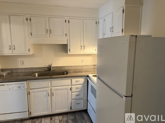 A kitchen with white appliances and cabinets.