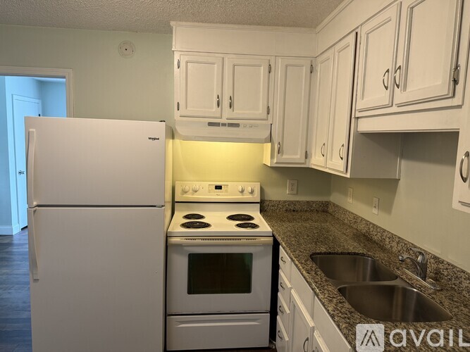 A kitchen with white appliances and cabinets.