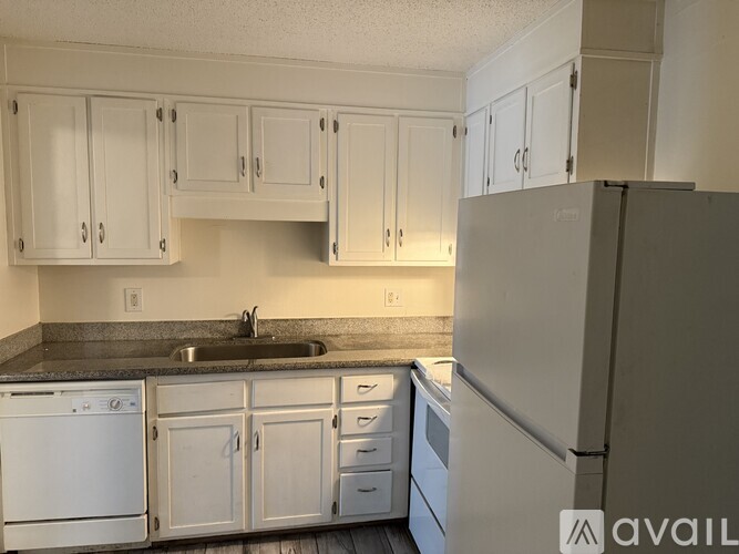 A kitchen with white cabinets and appliances.
