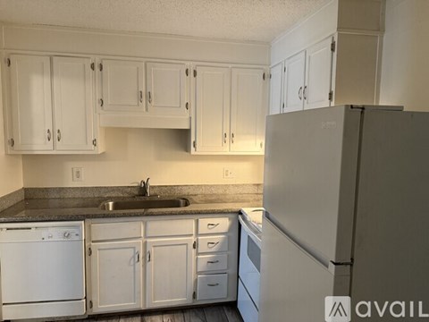 A kitchen with white cabinets and appliances.