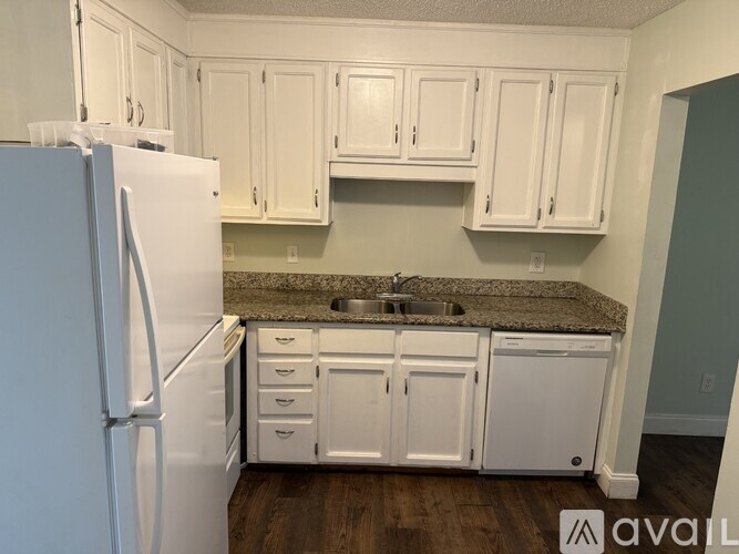 A kitchen with white cabinets and a granite countertop.