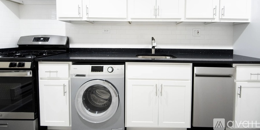 A black countertop with a sink and a washing machine.