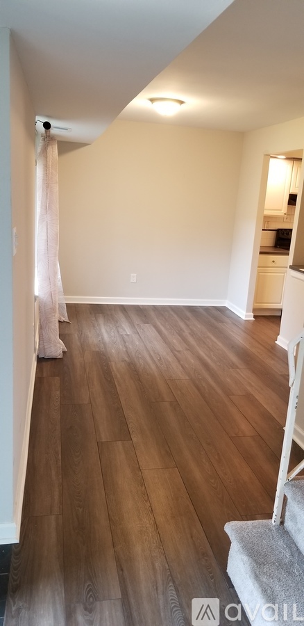 A room with wooden flooring and a staircase.