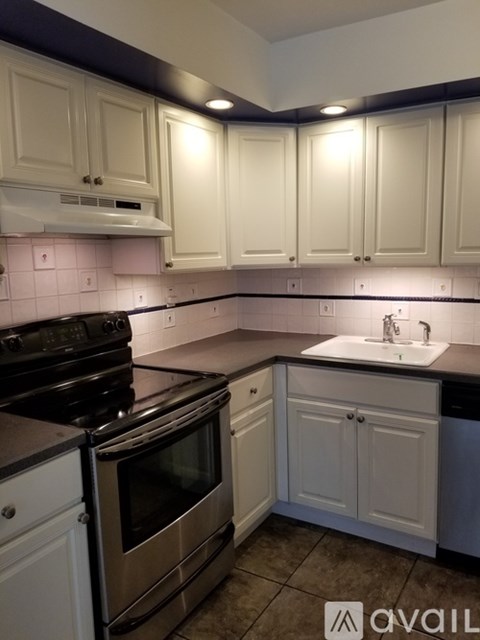 A kitchen with white cabinets and a black stove top oven.