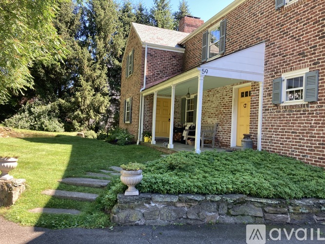 A house with a yellow door and a stone wall in front.