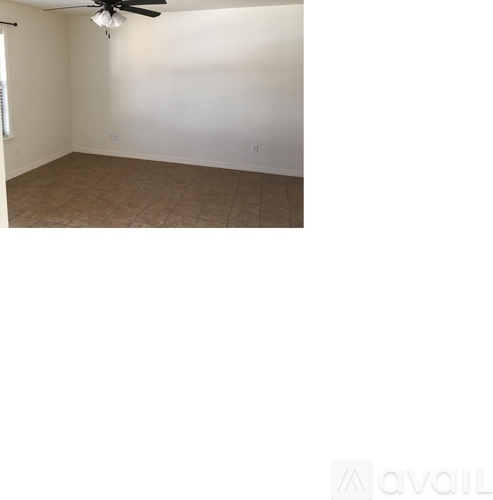 A room with a ceiling fan and carpeted floor.