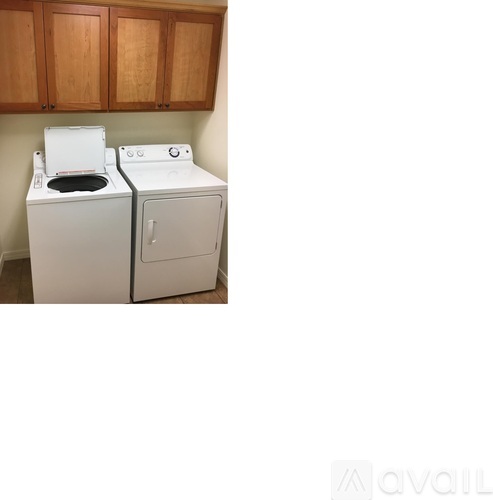 A white washing machine and dryer in a laundry room.