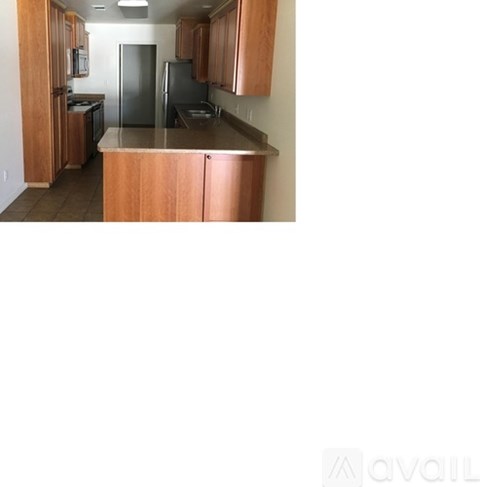 A kitchen with wooden cabinets and a refrigerator.