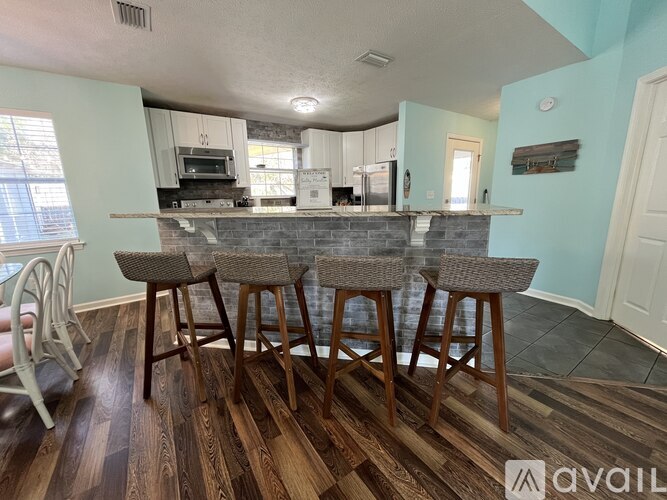 A kitchen with a bar area and four stools.