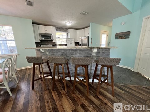A kitchen with a bar area and four stools.