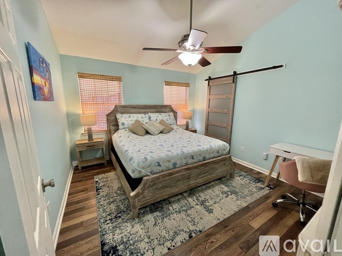 A bedroom with a bed, desk, and chair.