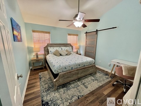 A bedroom with a bed, desk, and chair.
