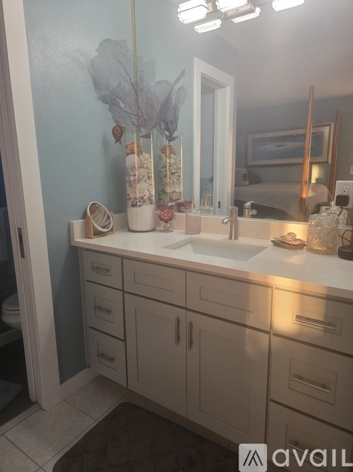 A bathroom with a sink, mirror, and decorative items.