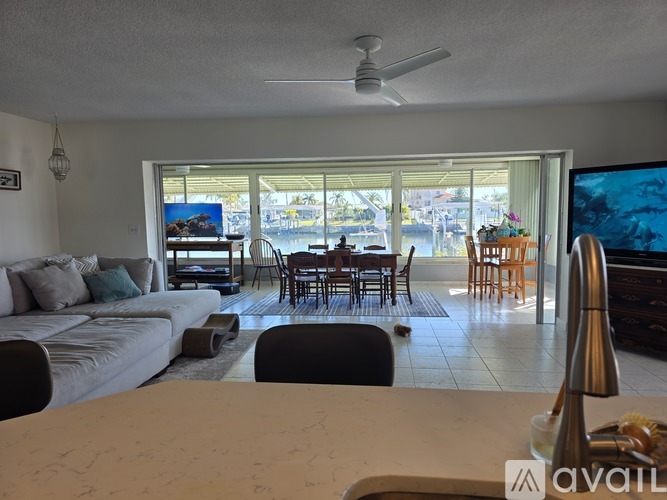 A living room with a couch, chairs, and a television.